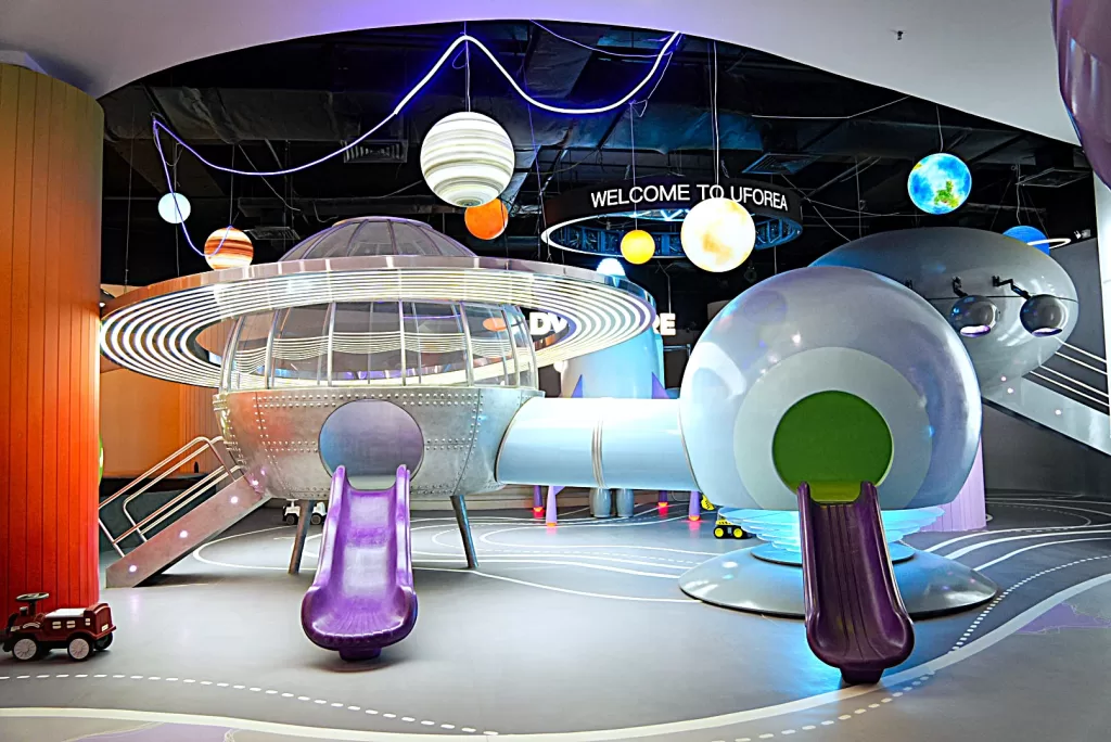 Pearl-white rocket with a gentle spiral slide inside UFOREA's Galaxy Exploration Zone, a space-themed zone for toddlers