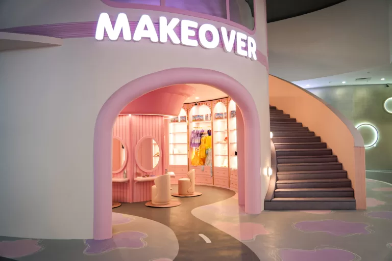 The pink-and-gold entrance archway of UFOREA's Makeover Castle, with princess gowns visible inside