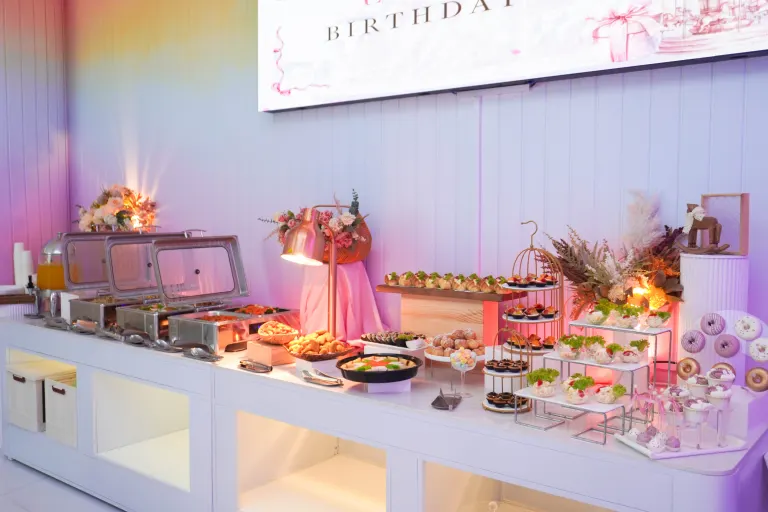 The birthday buffet spread at UFOREA Penang with chafing dishes, canapés, pastries and a donut wall under pastel lighting