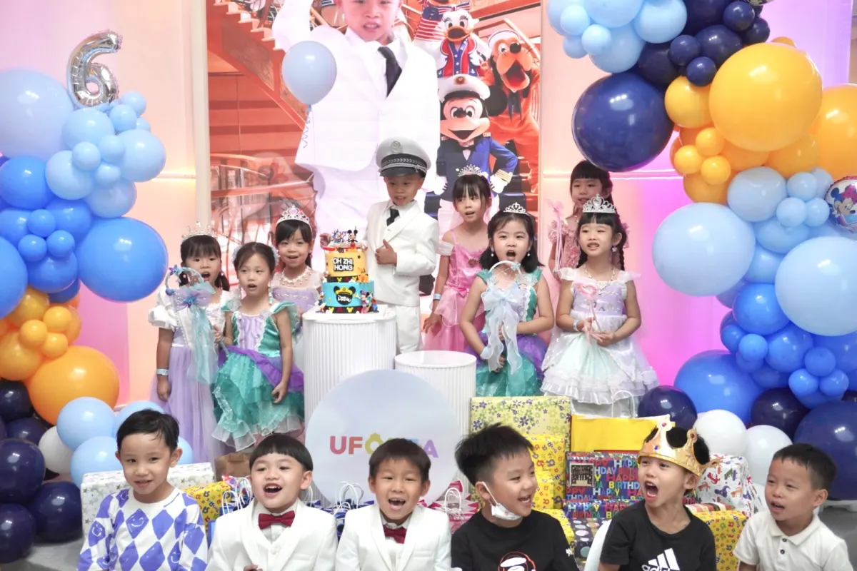 The birthday boy and his friends in dress-up costumes gathered around the cake at UFOREA Penang