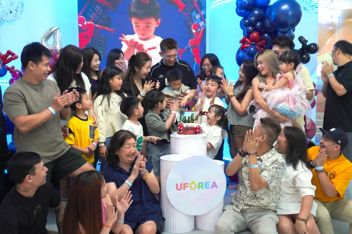 Three generations gathered around the cake at a superhero-themed birthday at UFOREA Penang