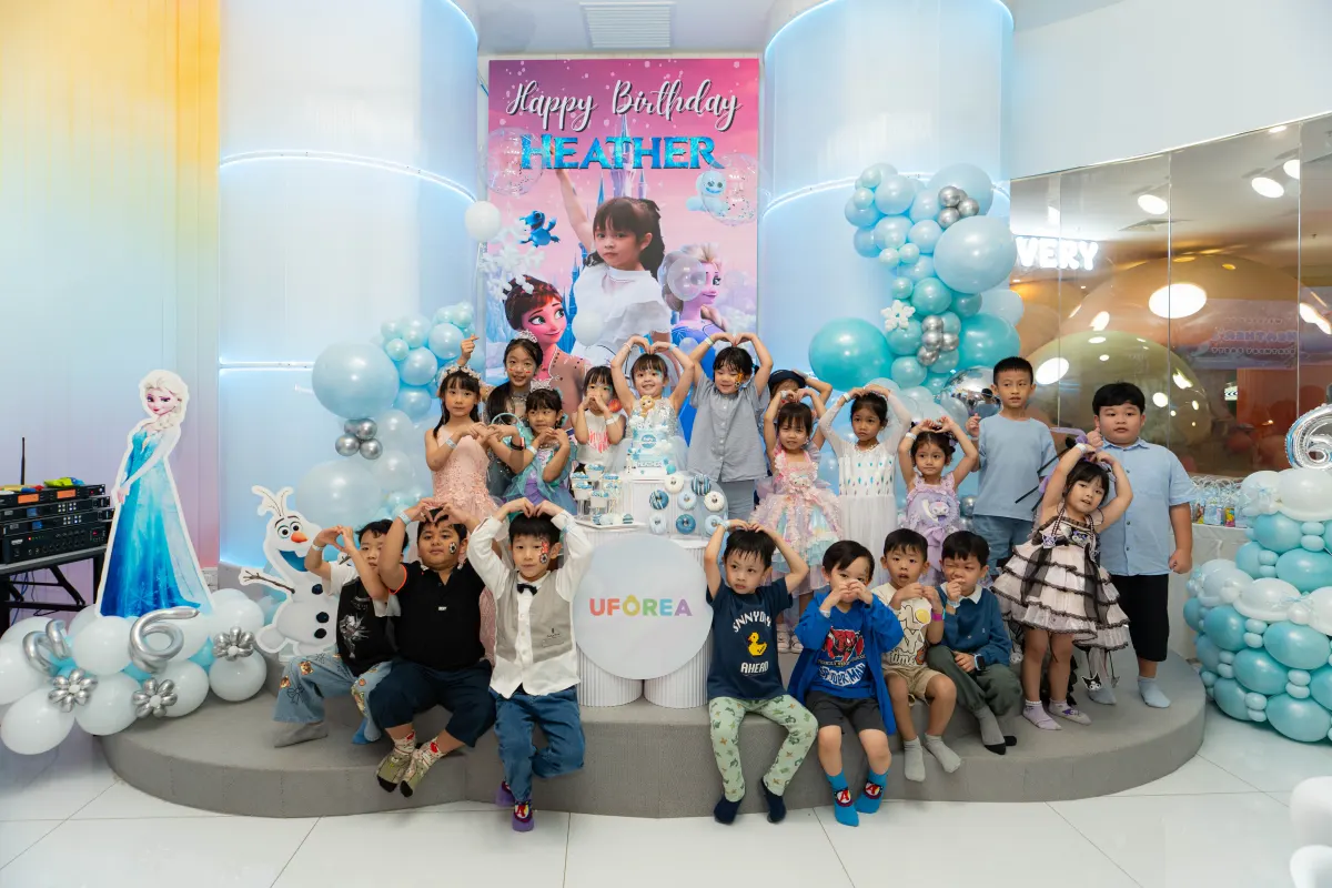 The whole party making heart signs at a winter-princess themed birthday at UFOREA Penang