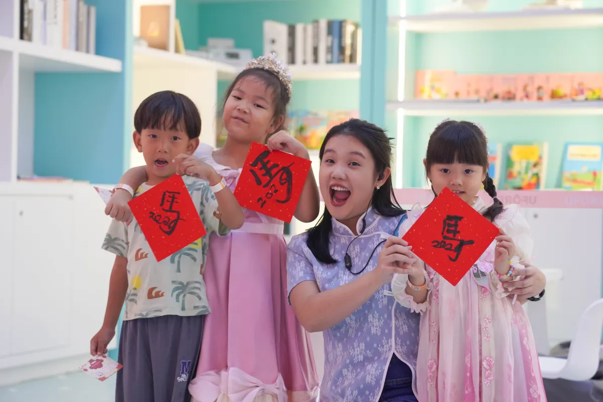 A UFOREA Penang host and young guests showing off their Chinese New Year calligraphy