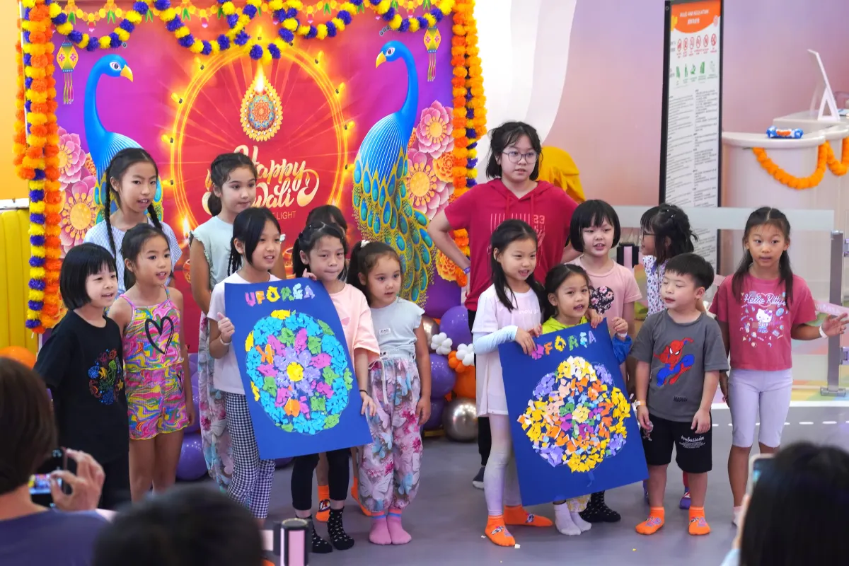 Children presenting their rangoli paper collages at the UFOREA Penang Diwali celebration