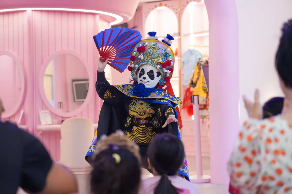 A Sichuan opera face-changing performer entertaining young guests at UFOREA Penang