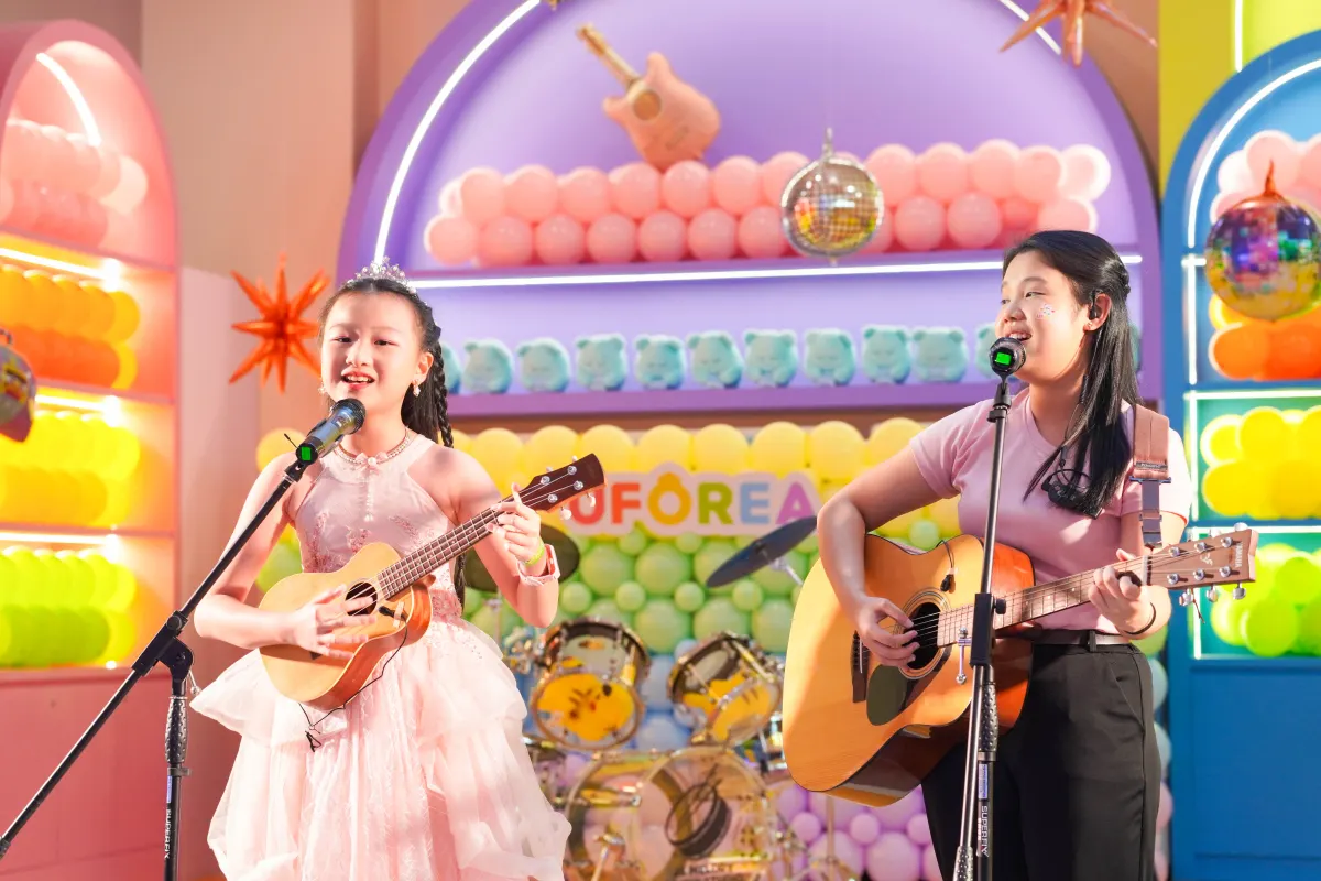 Two young musicians singing and playing guitar at the UFOREA Penang music showcase