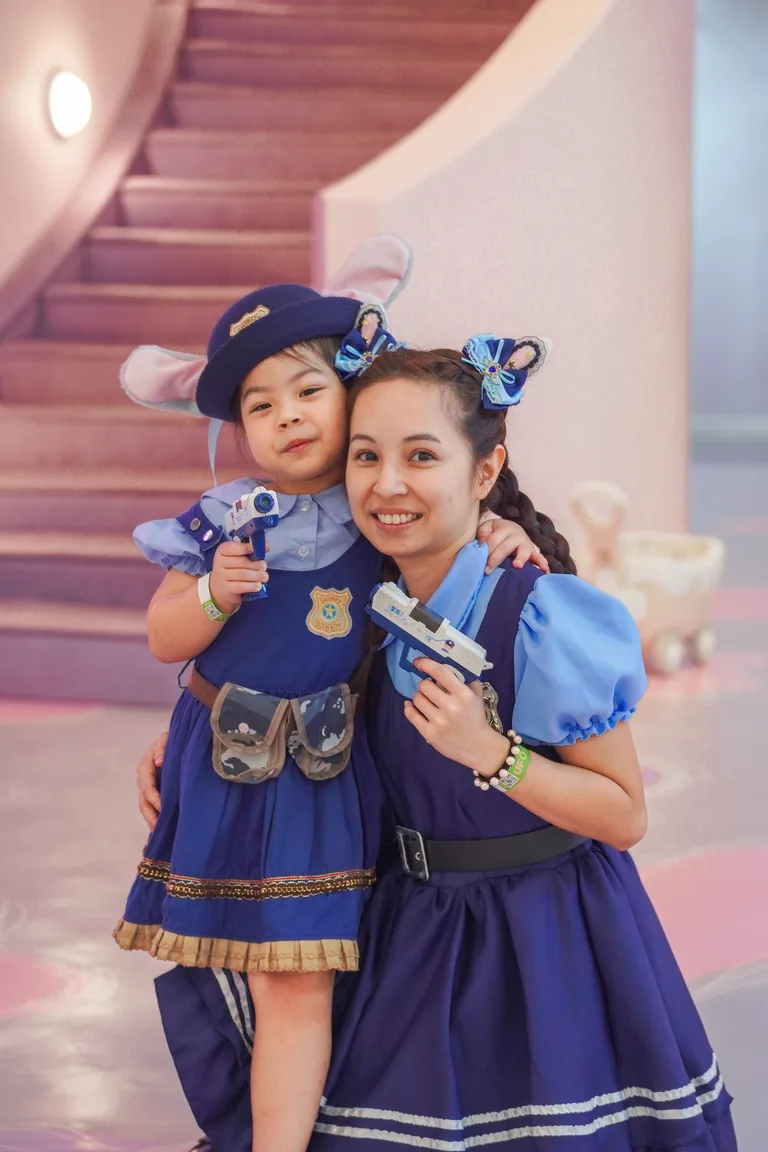 A parent and child smiling in matching costumes inside UFOREA Penang's Makeover Castle