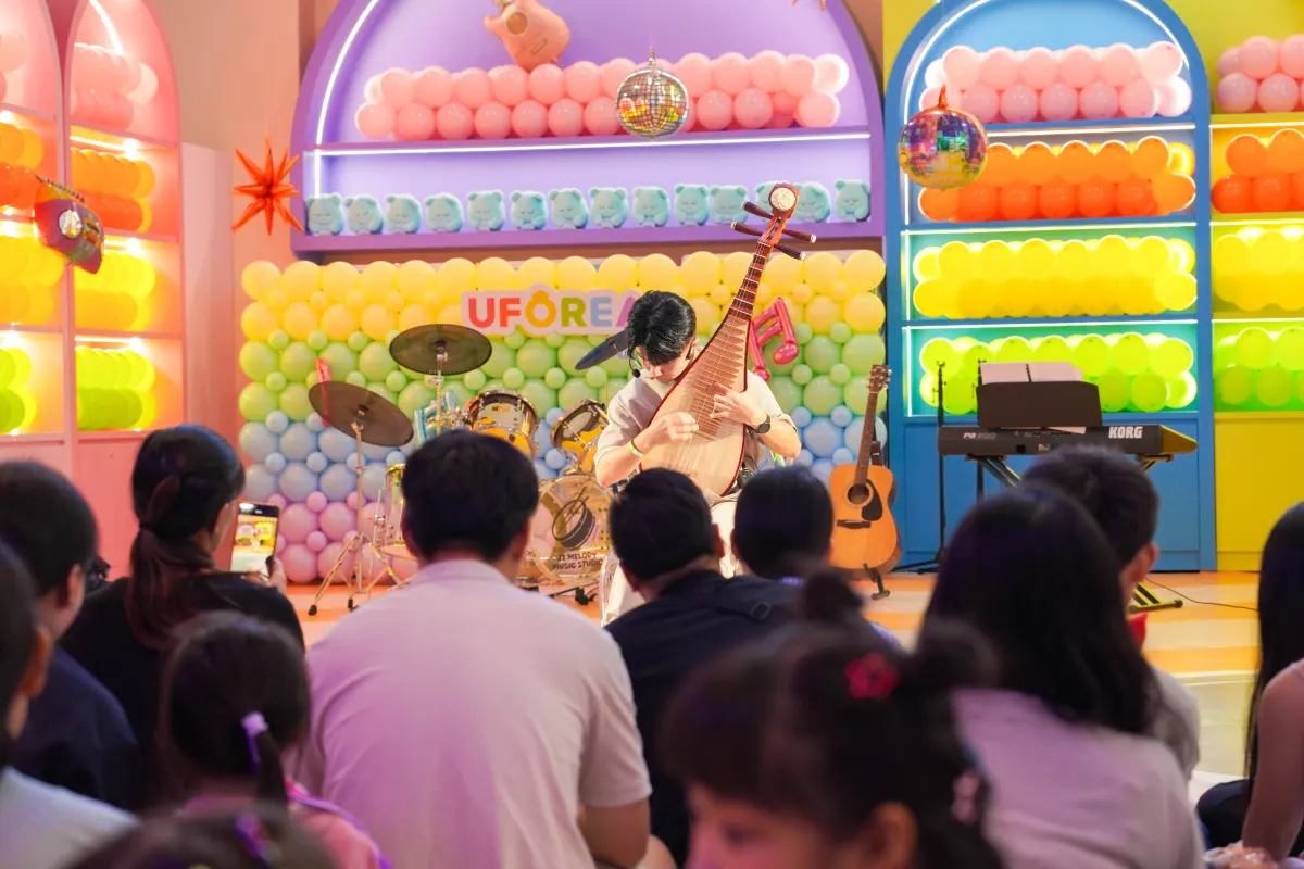 A pipa soloist performing on the balloon-decked stage at a UFOREA Penang event
