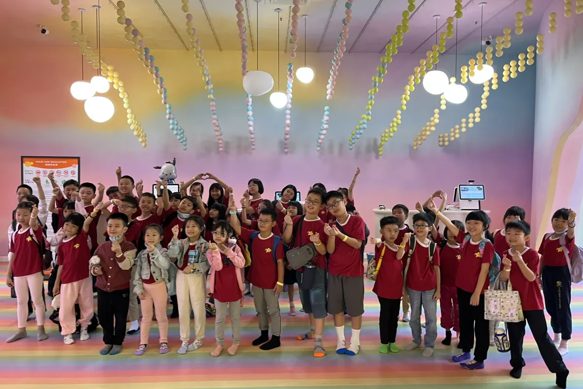 A school group waving in the rainbow ticket lobby at UFOREA Penang