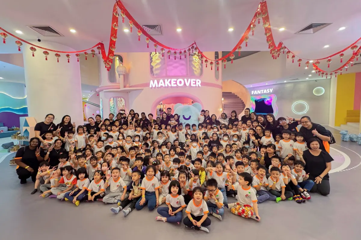 A full kindergarten posing with their teachers in front of the Makeover castle at UFOREA Penang