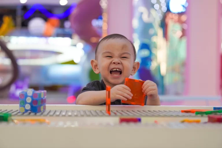 A toddler laughing inside a hollowed-out mushroom cap